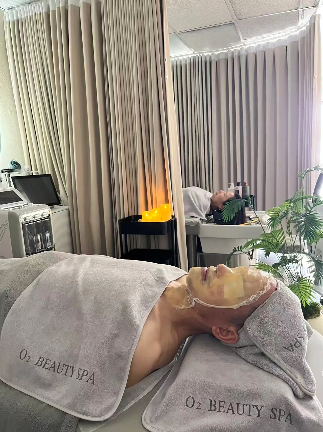 Facial in progress at O2 Head & Beauty Spa, the client wrapped in towels embroidered O2 Beauty Spa