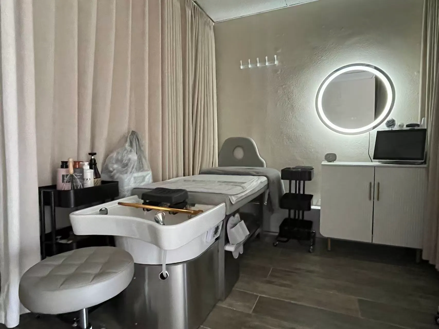 Head spa room at O2 Head & Beauty Spa in Arcadia, with the head spa bed, basin and a round lit mirror