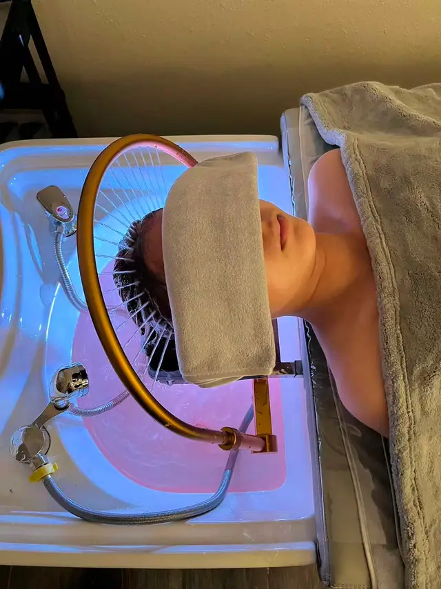 Head spa at O2 Head & Beauty Spa in Arcadia: a gold waterfall arch rinses a client's hair over a softly lit basin